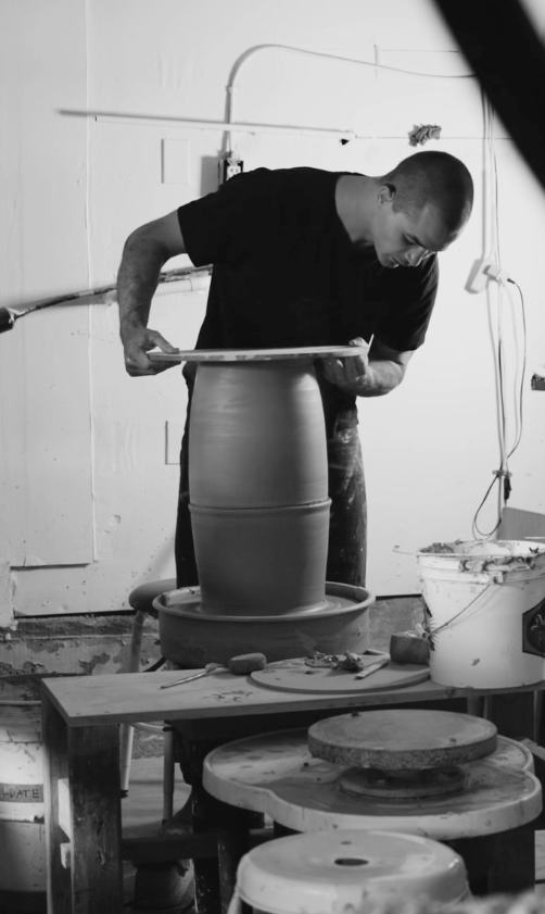 Theo teaching a private ceramics class. He is showing how to join two thrown forms.