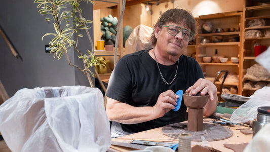 Ceramic artist Greg Lowe shaping architectural clay forms at Tao of Clay studio in San Diego