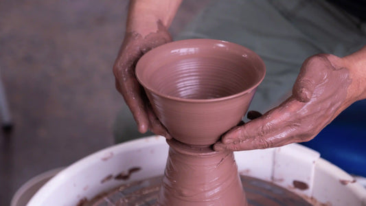 Jason Han throwing off the hump at Tao of Clay in San Diego, demonstrating a traditional pottery technique that creates multiple forms from one mound of clay.